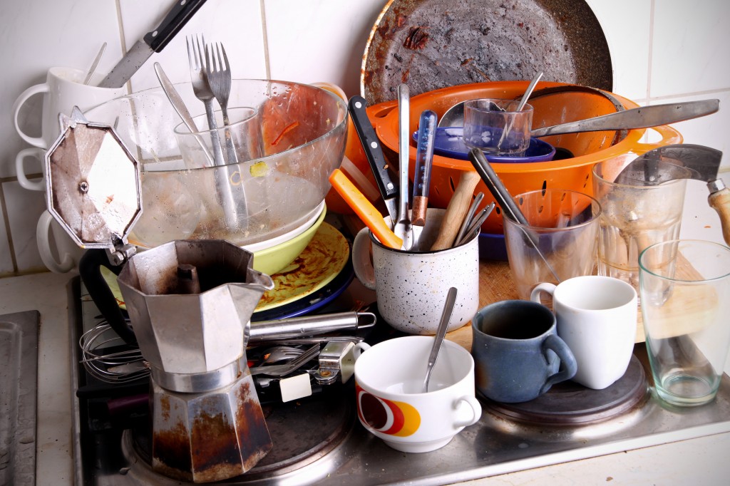 This is a ton of dishes sitting in the kitchen sink.