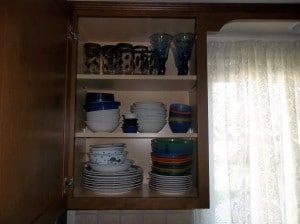 A disorganized mess of plates in our cabinet before we organized them.