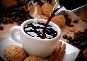 This is an image of hot coffee being poured into a cup surrounded by delicious cookies. Read our Chefman rj11-17-gp review.