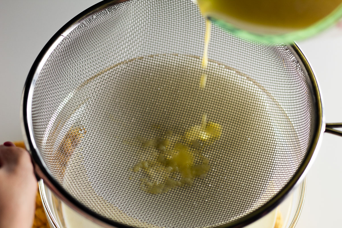 This is an image of the sweet cream ice cream mixture being poured through a mesh strainer.