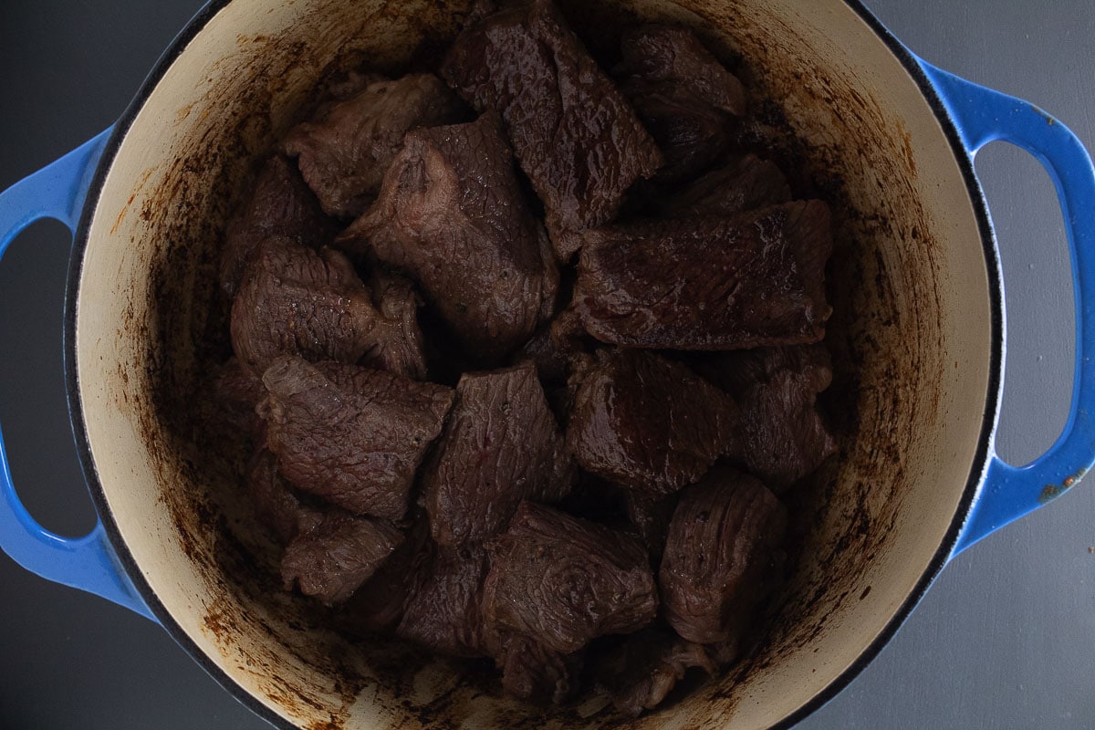 This image show the chuck roast browned  in a dutch oven.