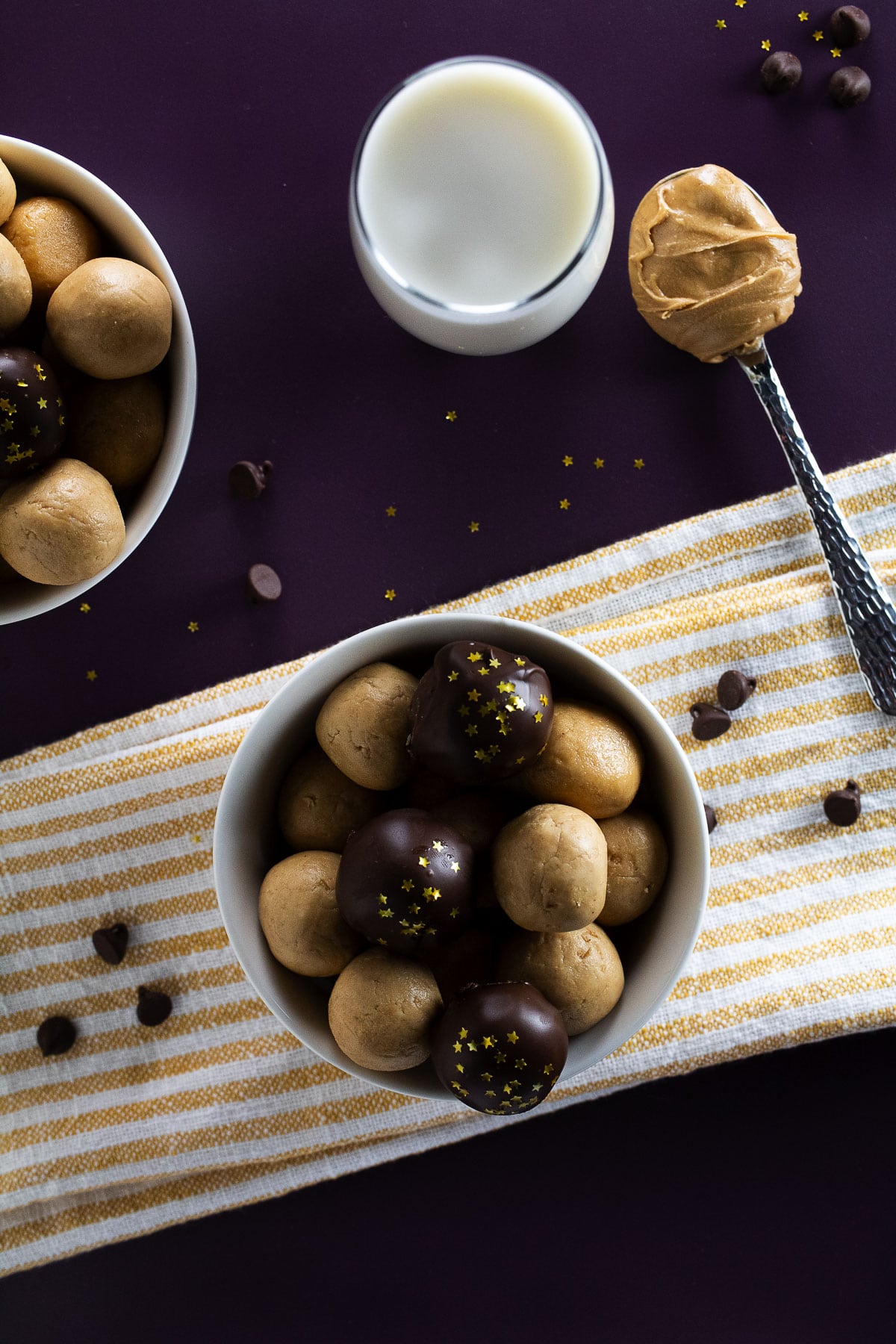 Overhead image of old fashioned peanut butter balls in a bowl with milk and peanut butter on the side.