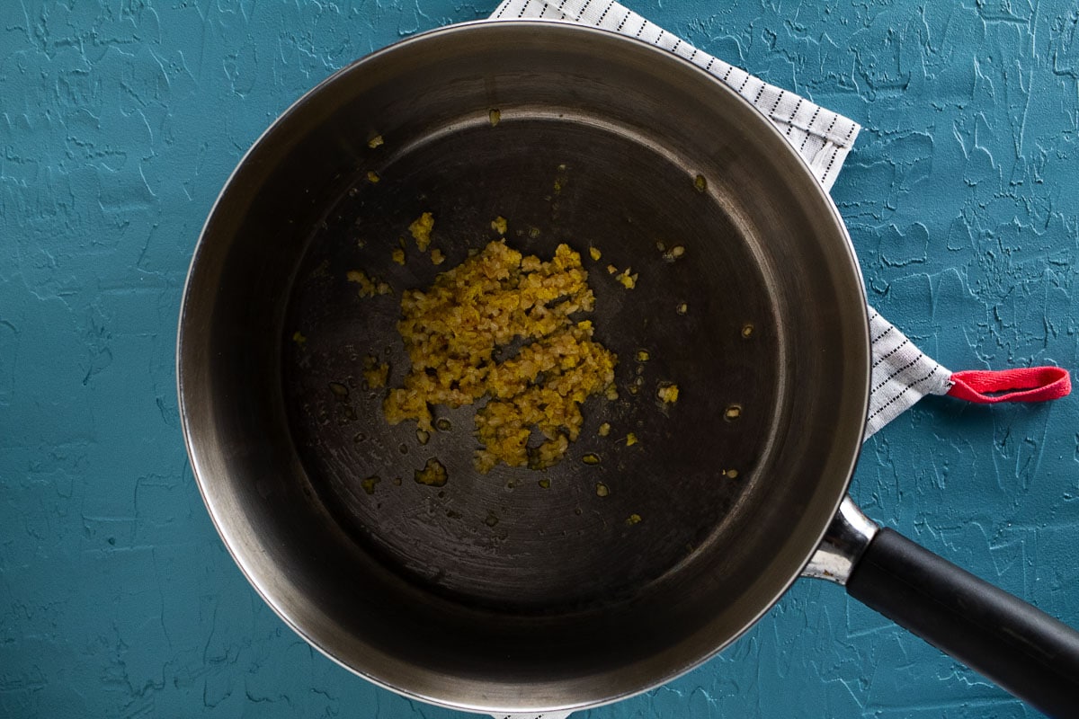 This image shows sautéing the garlic and ginger with sesame oil in a pan.