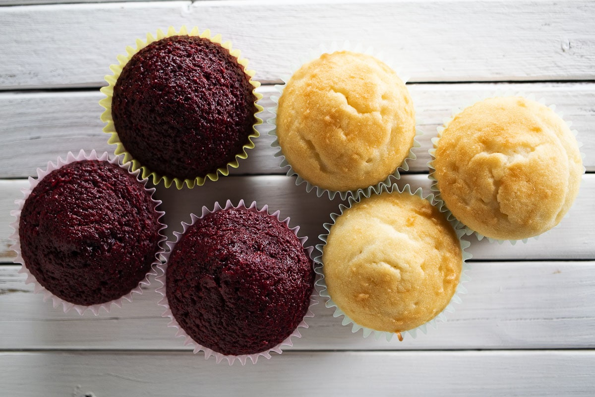 Pictured here is an image of red velvet and white cake cupcakes.