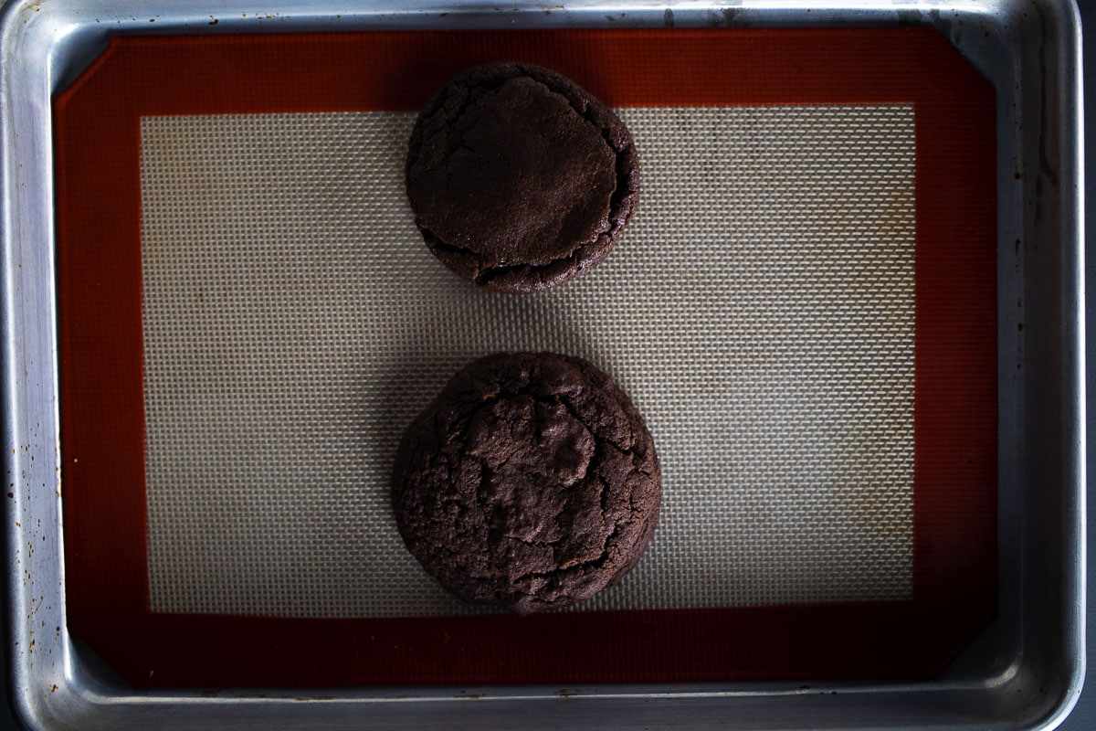 This image shows the difference between cookies made with cold cookie dough and warm cookie dough.