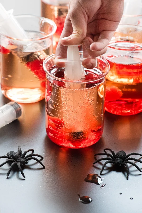 Creepy Halloween Shirley Temples served in chemistry beakers with syringe.