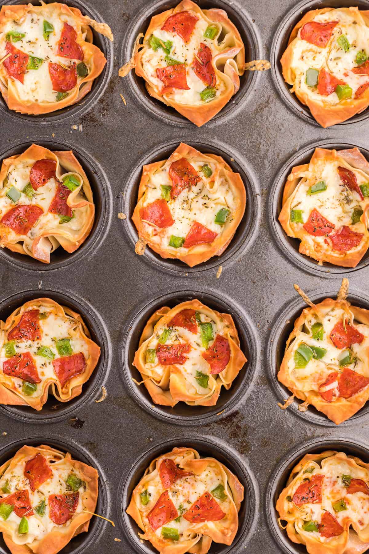 Pizza wontons in a muffin tin.