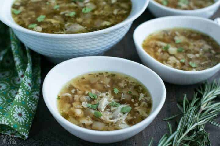 Instant pot chicken thighs soup in multiple white bowls with dark background.