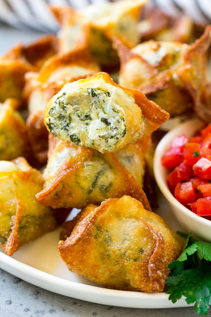 Fried spinach and artichoke wontons on plate with salsa.