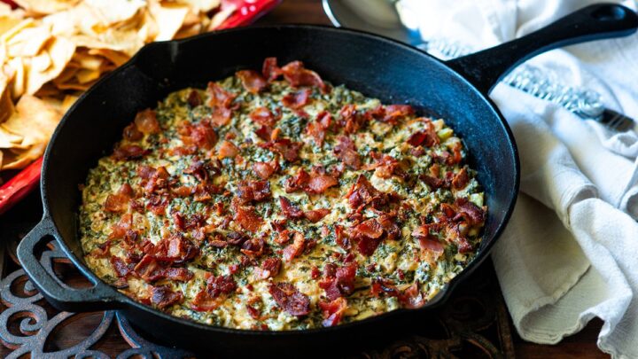 Asiago kale dip with bacon in a cast iron pan.