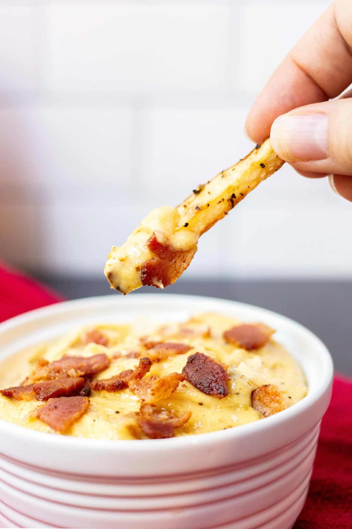 Fry in hand being dipped into bacon aioli.
