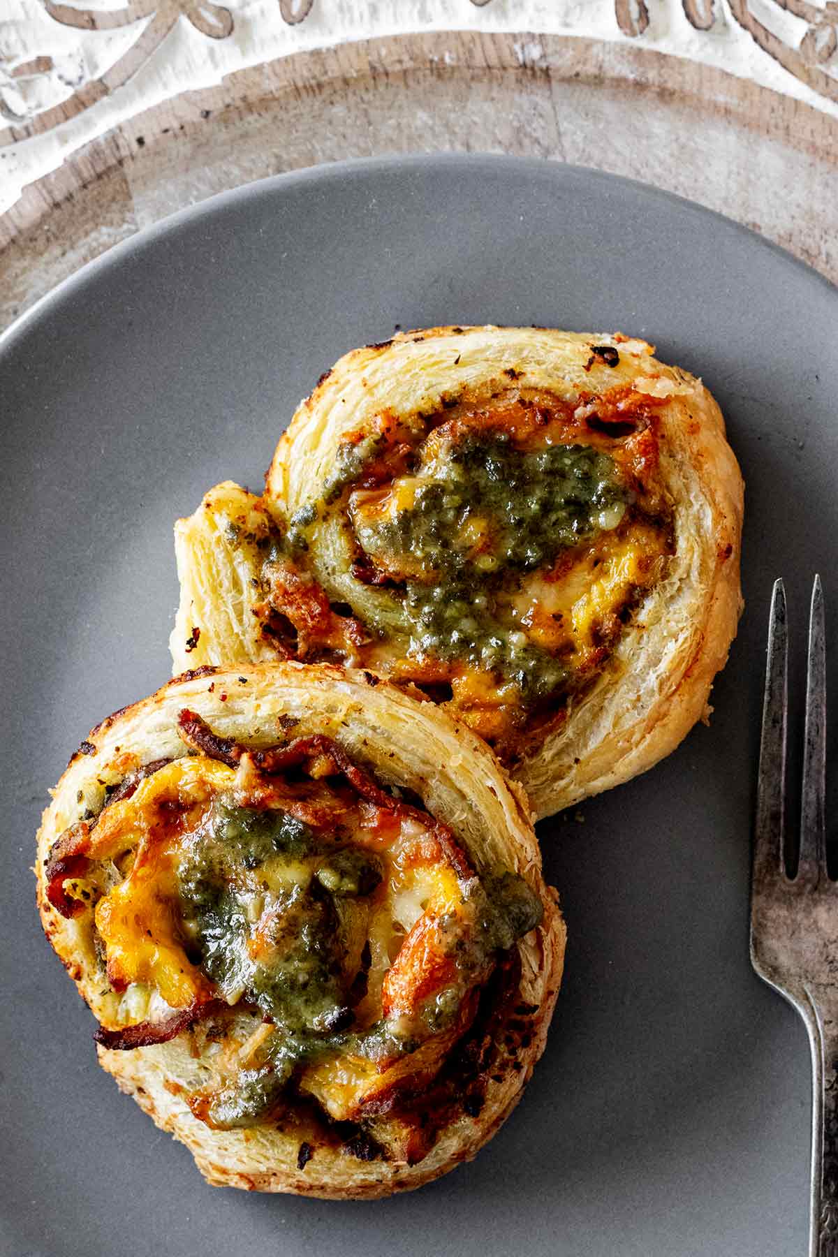 Breakfast puff pastry pinwheels on grey plate.