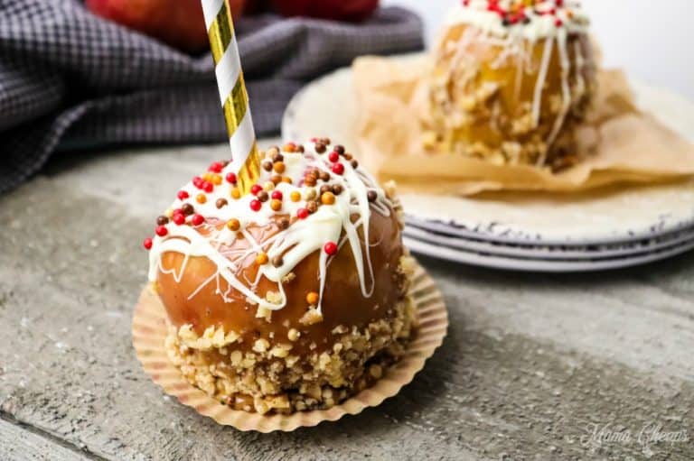 Walnut white chocolate caramel apple on grey background.