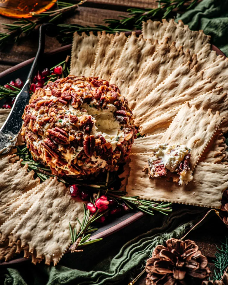 Cheese ball with crackers and festive decorations.