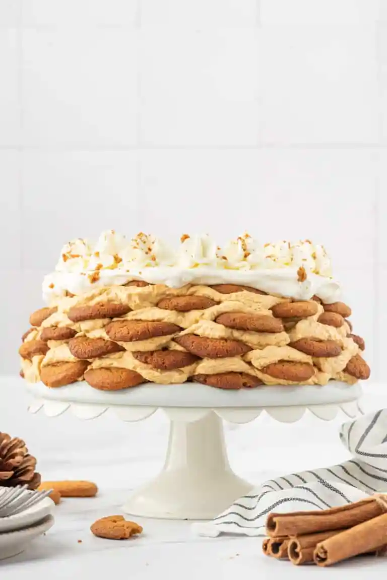 Gingersnap pumpkin ice box cake on cake stand with white background.