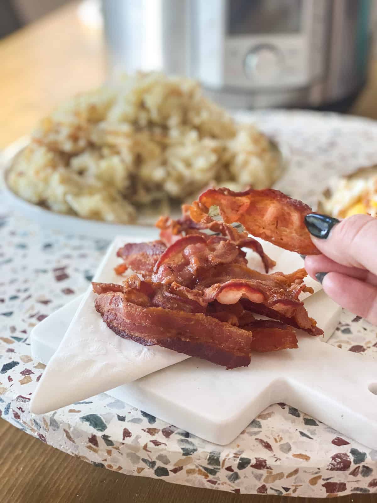 Bacon in hand with more in background.