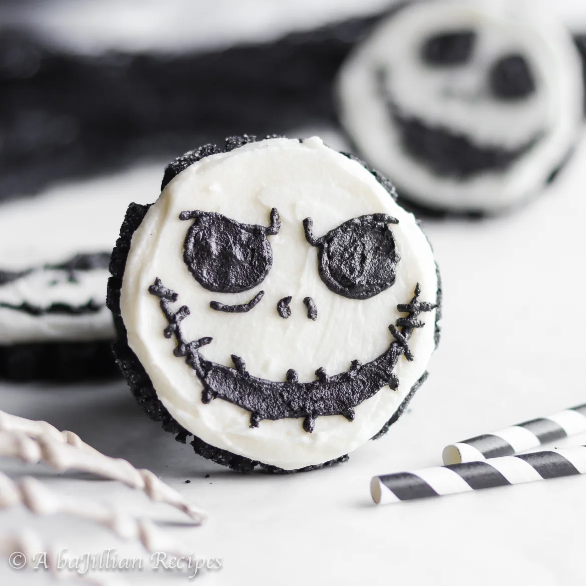 Cookie in the likeness of Nightmare Before Christmas character, Jack Skellington with straws and more cookies in the background.