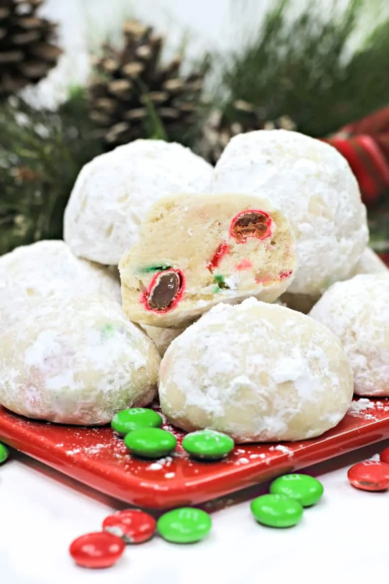 Christmas snowball cookie platter on a square plate with plain m&m's in the foreground.