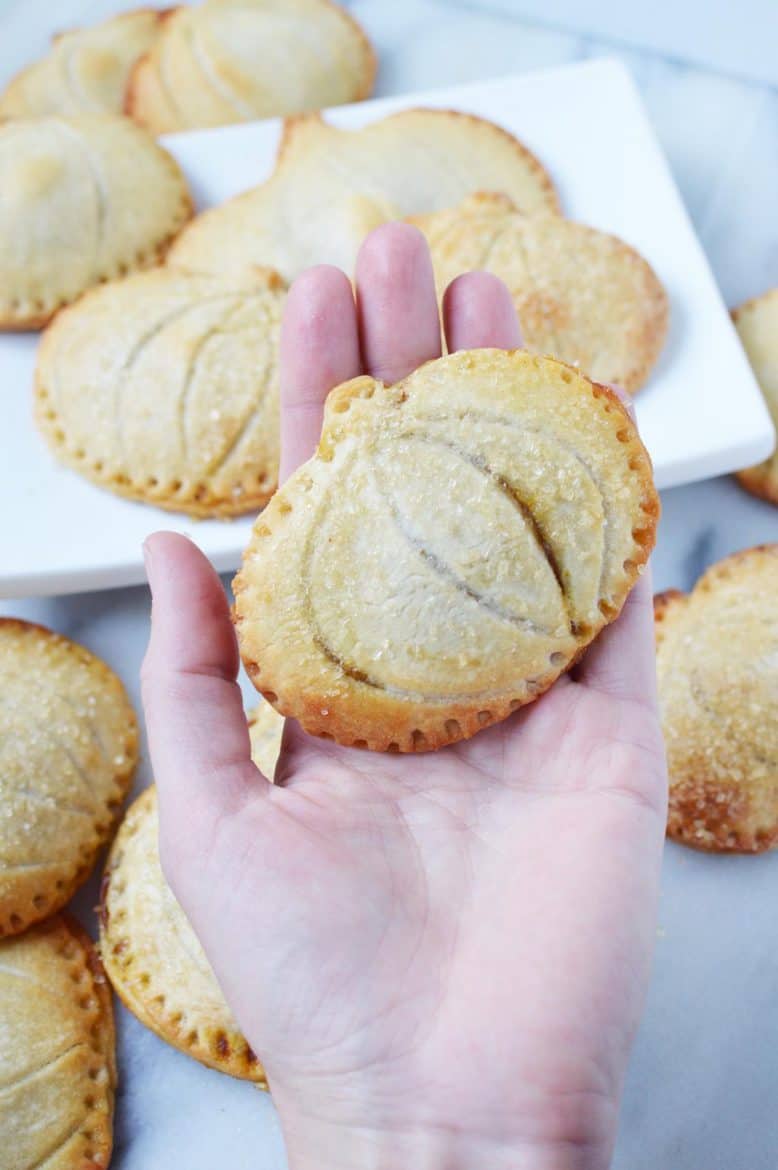 Pumpkin hand pies held in hand.