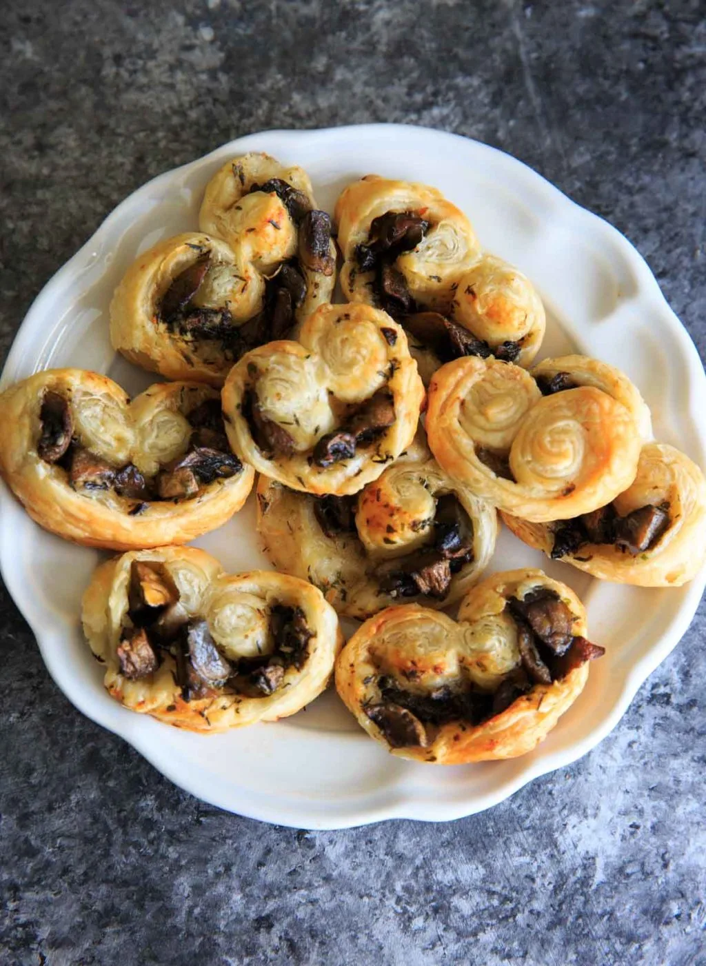 Mushroom puff pastry palmiers on a white plate.