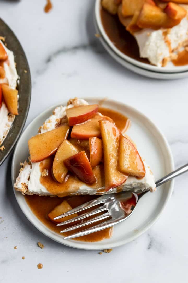 No bake caramel apple cheesecake slice on a plate with a fork.