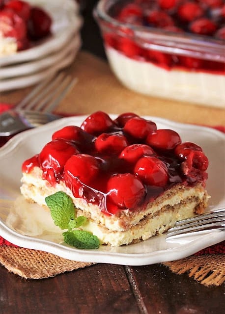 Slice of no bake cherry eclair dessert on a white plate.