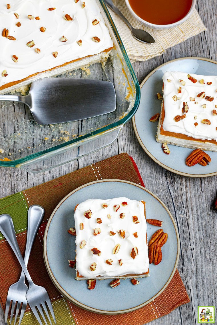 Pumpkin layered dessert in glass pan with forks and napkins and plates.