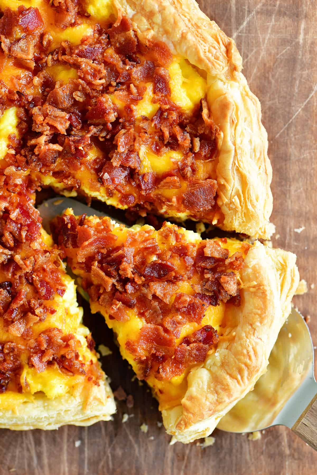 Puff pastry breakfast pizza on wooden cutting board.