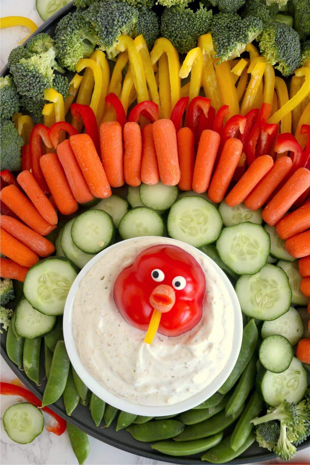 Vegetable tray arranged like turkey with veggie dip.