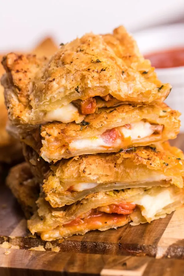 Stack of air fryer puff pastry pizza pockets.