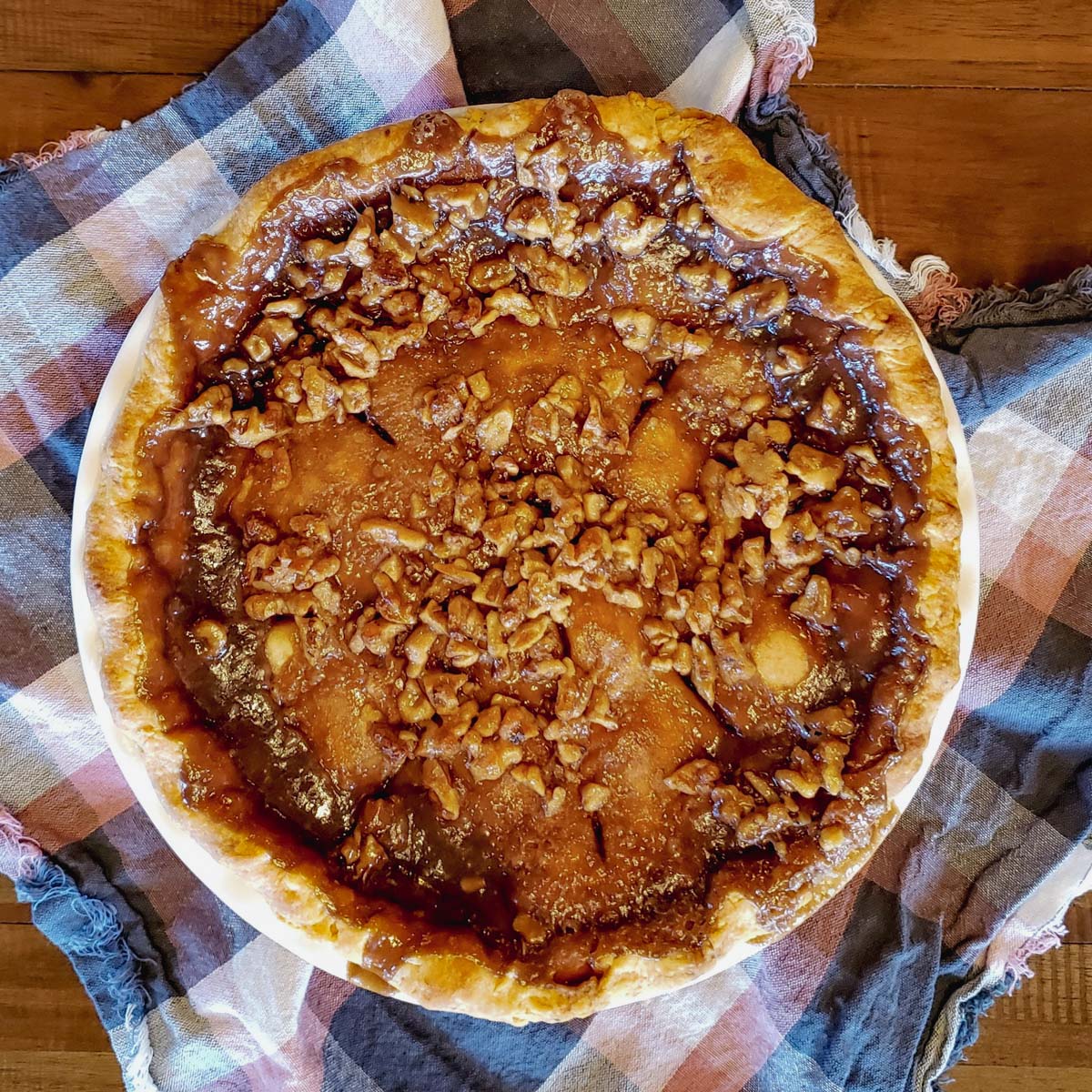 Whole caramel apple pie on cloth.