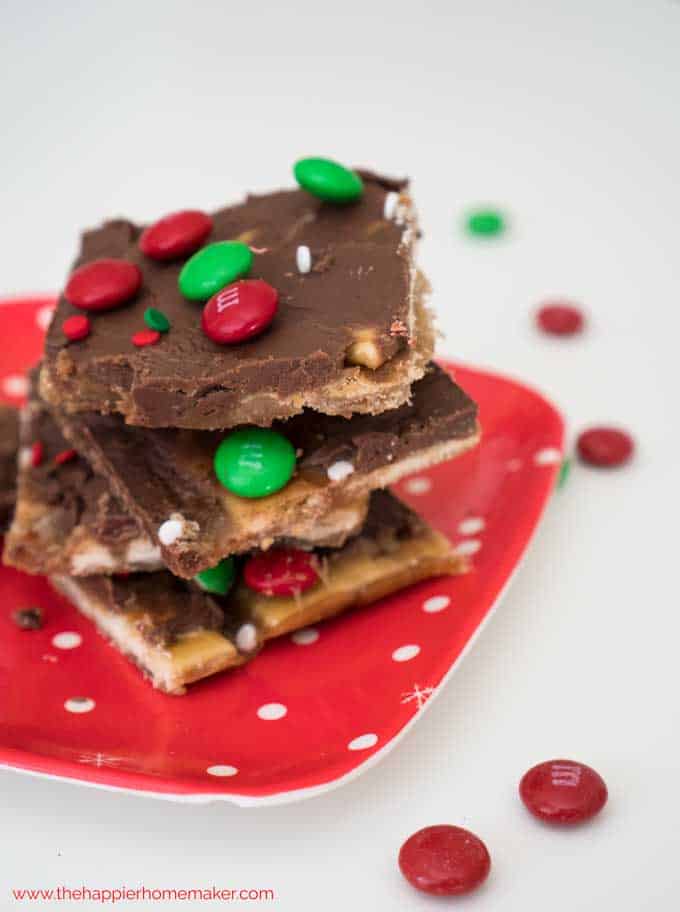 Saltine toffee candy pieces with m&m's on a red plate.