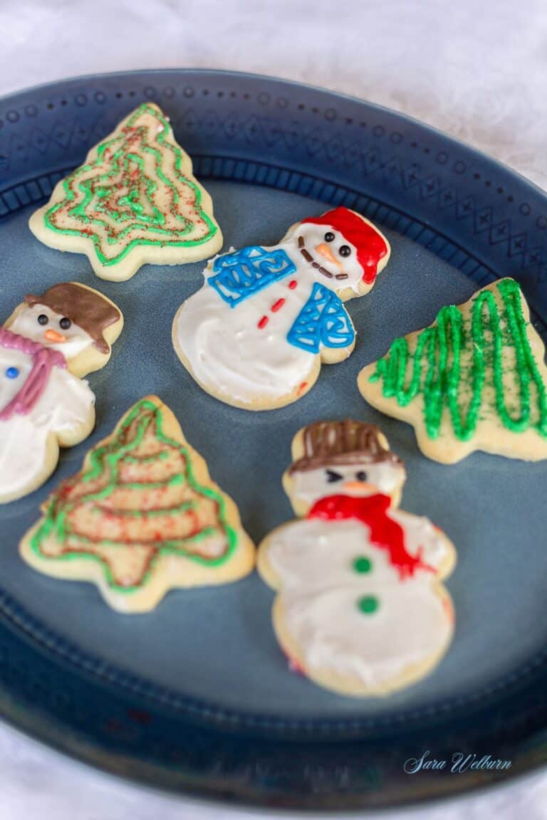 Assorted Christmas cookie shapes on a blue plate.