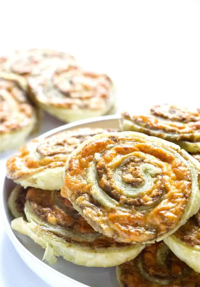Olive and cheese pinwheels pn a plate.