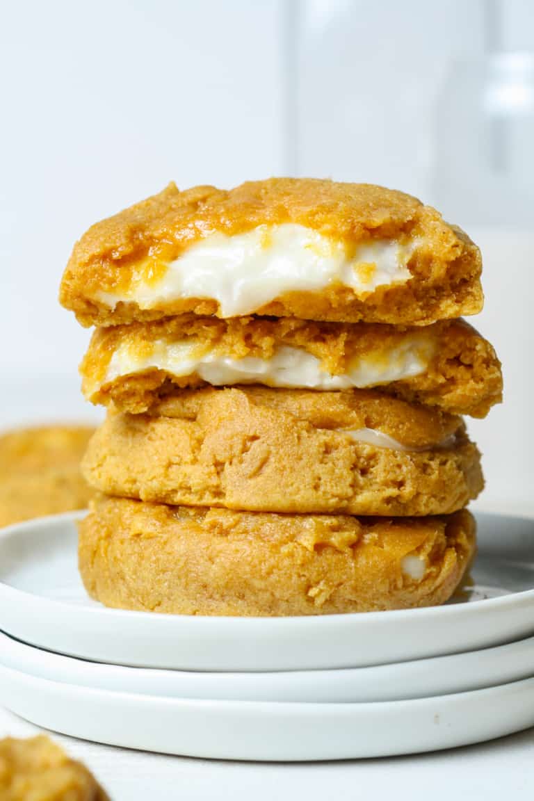 Stack of pumpkin cheesecake cookies on white plate.