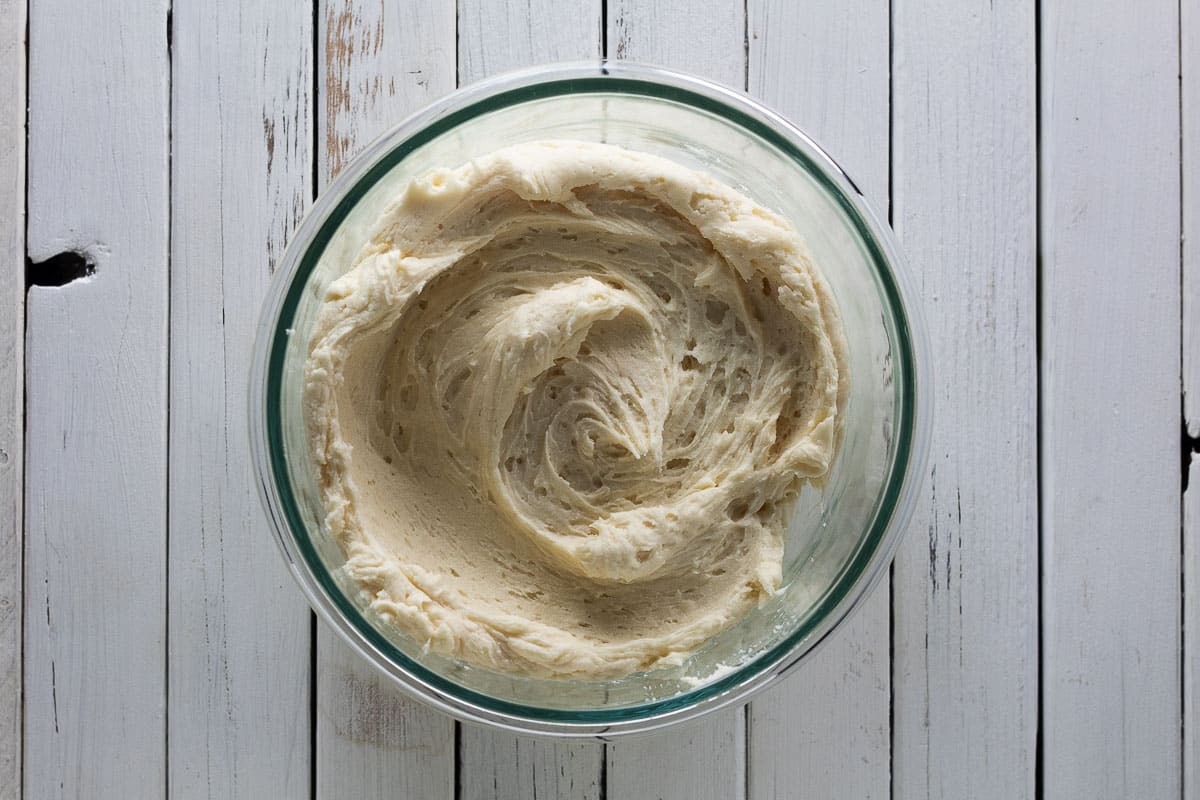 Maple frosting in a clear container with white background.