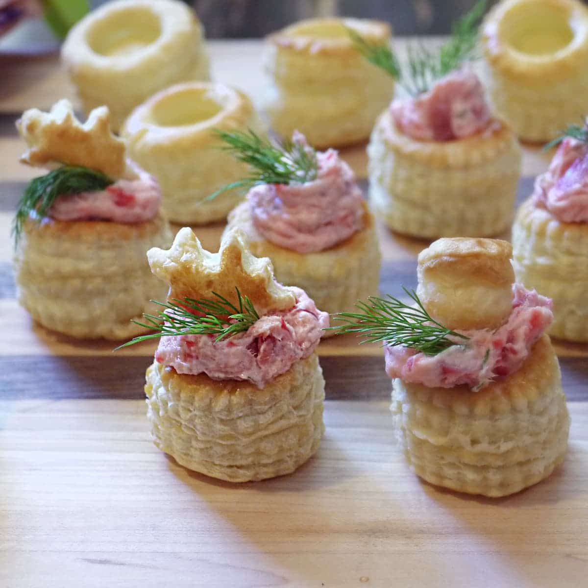 Smoked salmon puff pastry cups on wooden background.