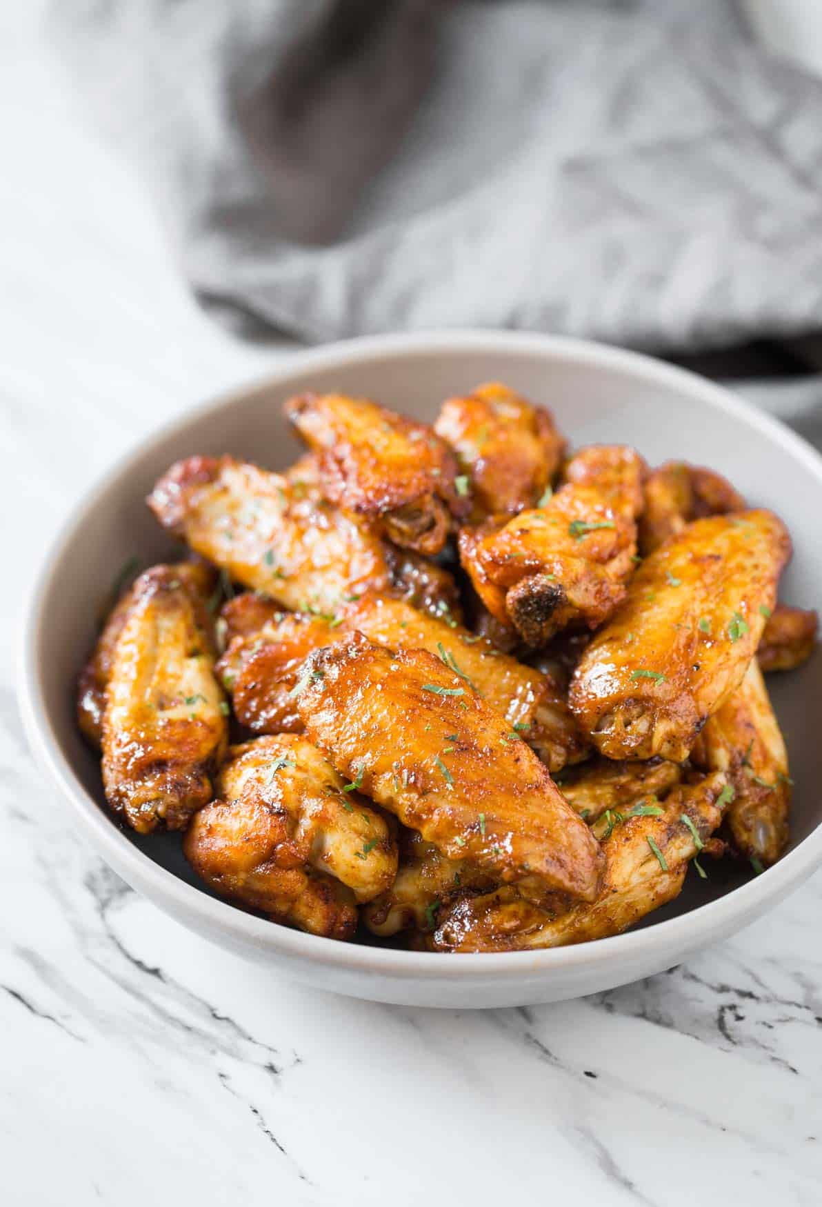 Air fryer buffalo chicken wings in a white bowl.