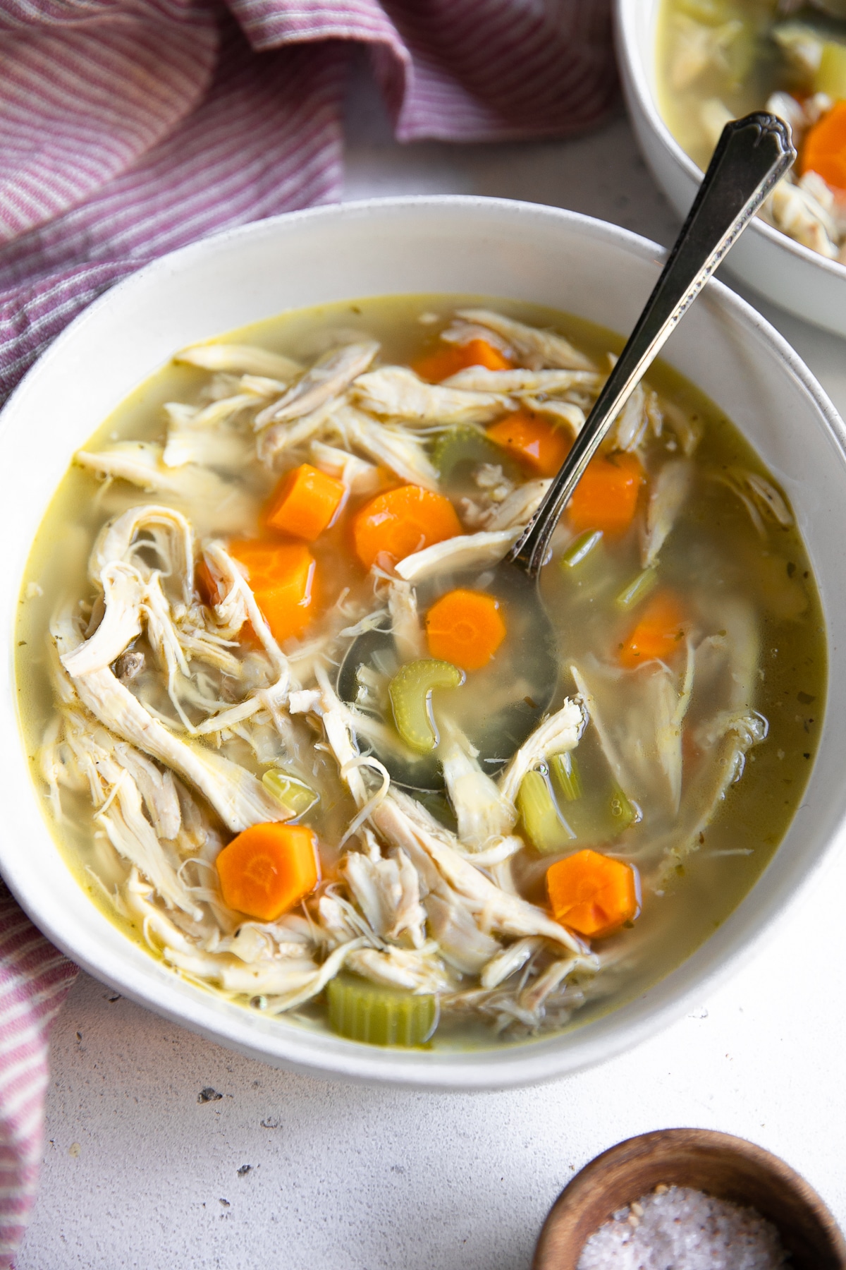 Chicken soup in a bowl with a spoon.