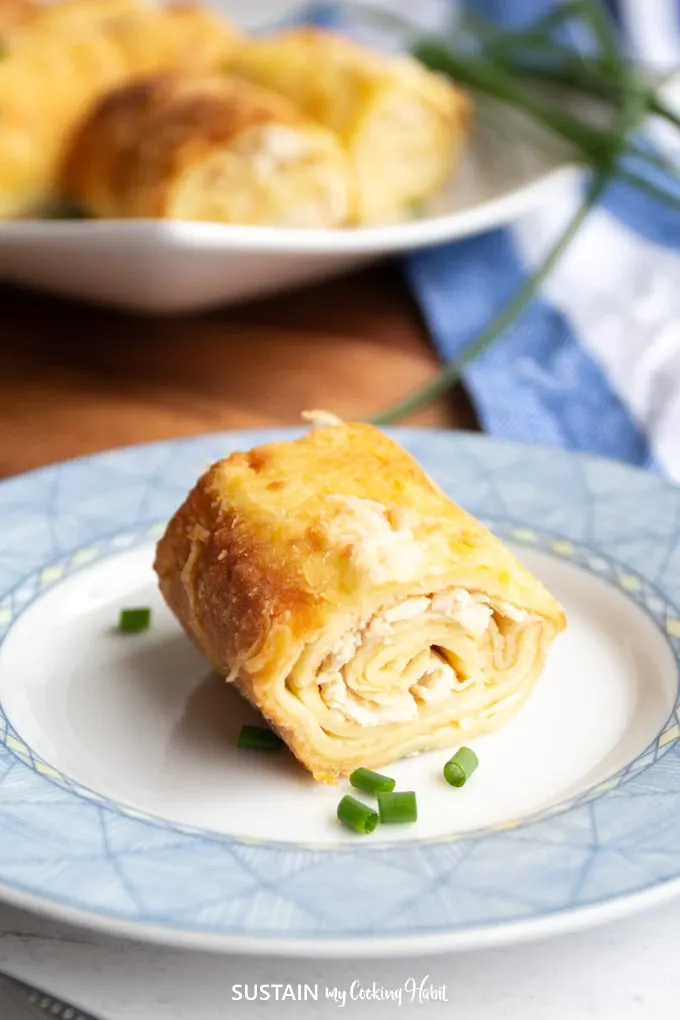 Rolled chicken crepe on  a blue plate.