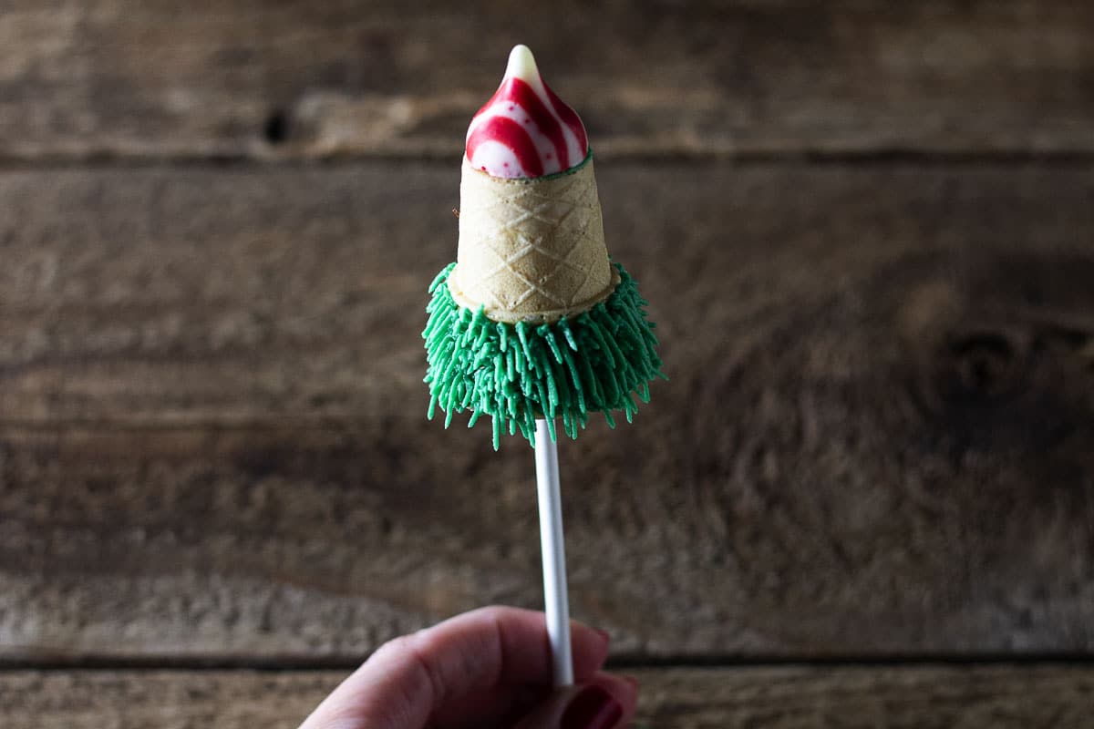 Cake cone filled with cake with a bit of frosting.