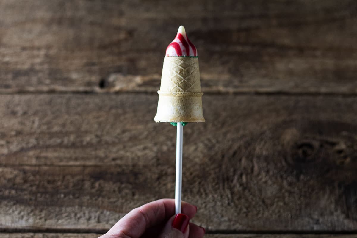 Baked cake filled cake cones with peppermint kiss on a stick.