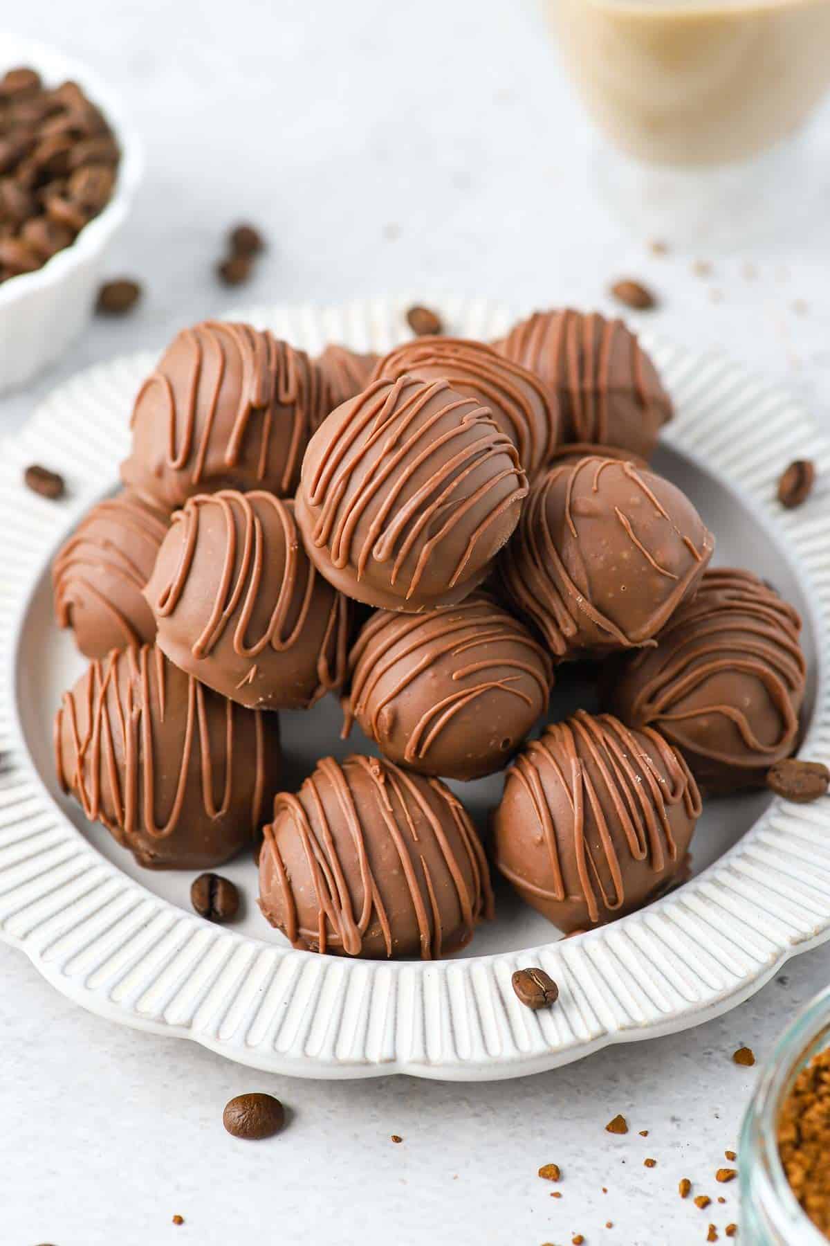 chocolate coffee truffles on a white platter.