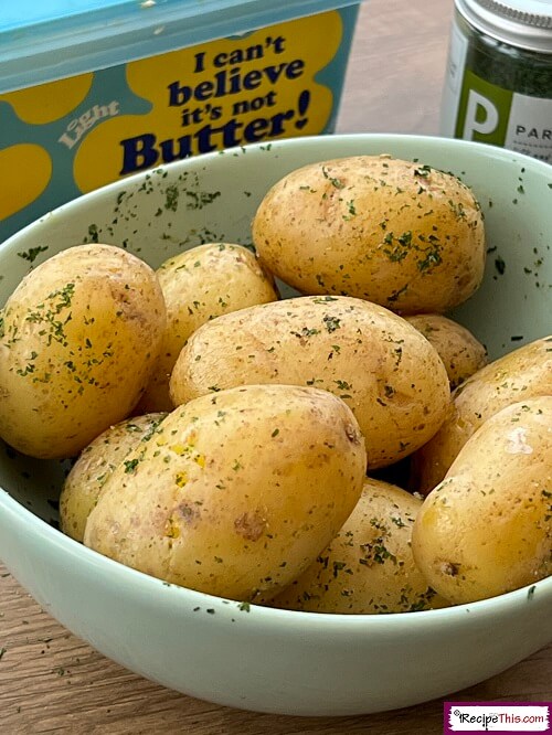 Microwaved baby potatoes with herbs in a bowl.