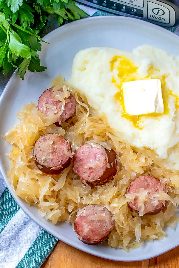 Kielbasa kapusta on a plate with potatoes.