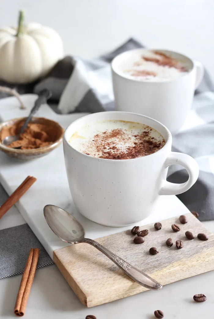 Creamy pumpkin spice latte in white mug.