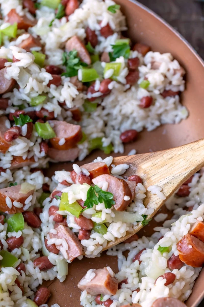 Red beans and rice in a skillet with a wooden spoon.