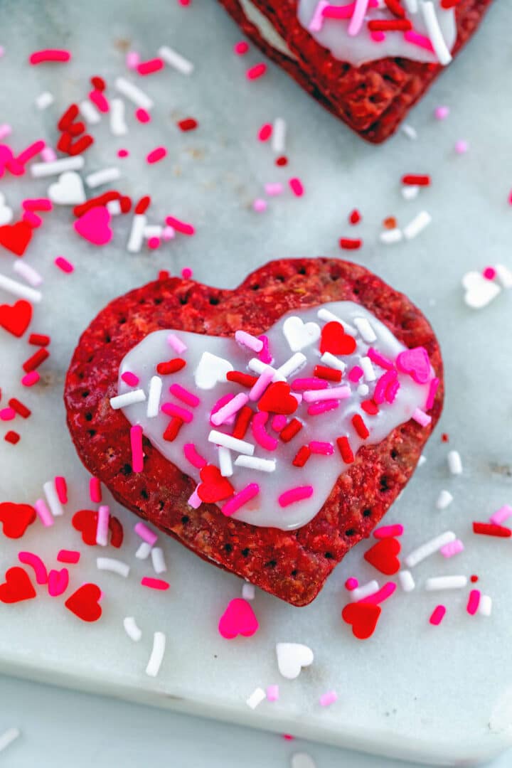 Heart shaped red velvet pop tarts with Valentine's sprinkles.