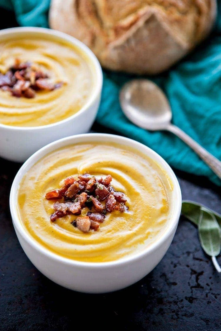 Butternut squash soup with bacon and sage in a bowl.