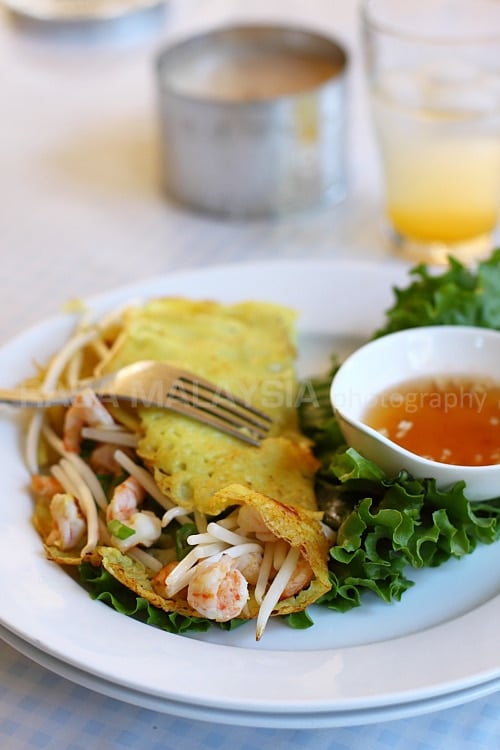 Vietnamese crepe on a white plate nuoc cham sauce.